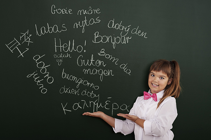 Schoolgirl presenting foreign phrases on blackboard