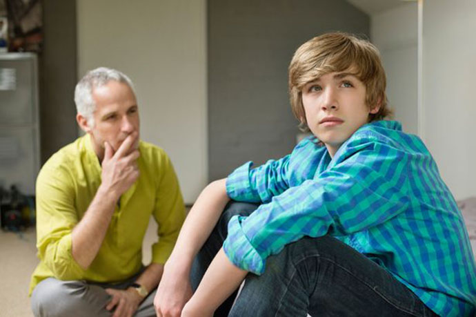 Man-sitting-with-his-son-looking-upset