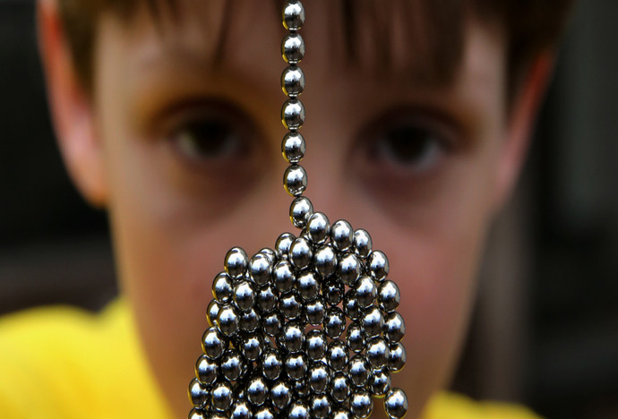 Brandon Bruski, 9, holds dozens of Buckyballs on Thursday, April 11, 2013 in Crystal Lake, Illinois.  In January, Brandon accidentally swallowed two balls from this set of the small magnetic desk toys.  The magnets left Brandon with a small and large intestine bound together.  Emergency surgery was required. (Chris Sweda/Chicago Tribune/MCT via Getty Images)