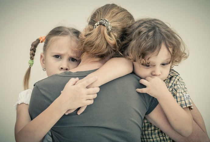 sad children hugging his mother