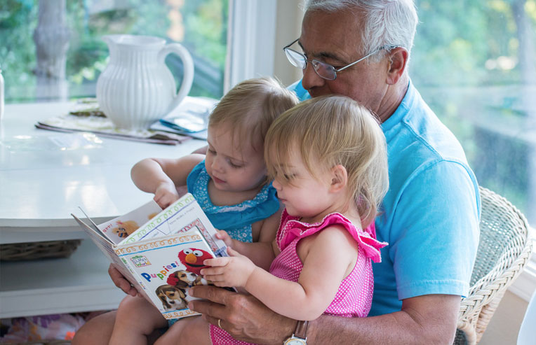 grandfather-reading-a-story-for-twin-girls