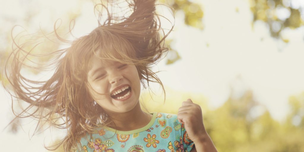 Young girl laughing with hair blowing